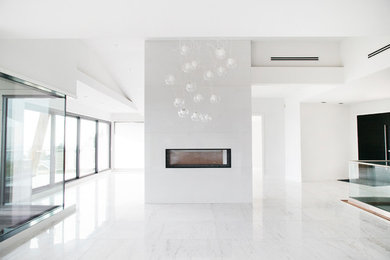 Идея дизайна: огромная гостиная-столовая в стиле модернизм с белыми стенами, мраморным полом, горизонтальным камином, фасадом камина из камня и белым полом