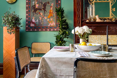Idées déco pour une salle à manger éclectique avec un mur vert et un sol en bois brun.
