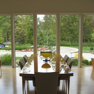Exemple d'une salle à manger ouverte sur le salon moderne de taille moyenne avec un mur blanc, un sol en bois clair et aucune cheminée.