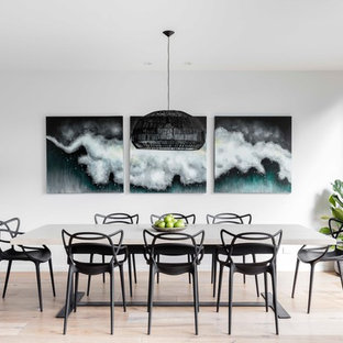 This is an example of a mid-sized modern kitchen/dining combo in Sydney with white walls and light hardwood floors.