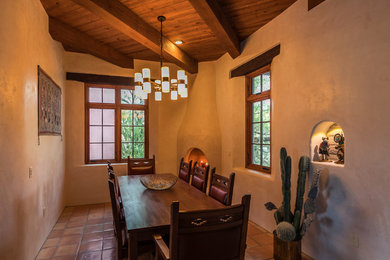 Southwest terra-cotta tile and pink floor dining room photo in Other with white walls and a corner fireplace