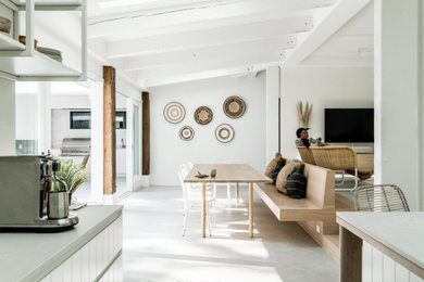 Источник вдохновения для домашнего уюта: огромная гостиная-столовая в морском стиле с белыми стенами, бетонным полом и серым полом