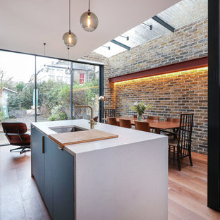This is an example of a medium sized contemporary kitchen/dining room in London with medium hardwood flooring and brown floors.