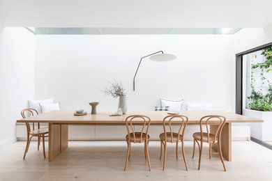 Стильный дизайн: столовая в стиле модернизм с белыми стенами, светлым паркетным полом и бежевым полом - последний тренд