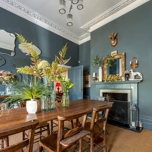 This is an example of a medium sized classic enclosed dining room in Other with blue walls, carpet, a standard fireplace and brown floors.