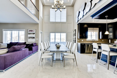 Immagine di una grande sala da pranzo aperta verso la cucina tradizionale con pareti bianche, pavimento in marmo e nessun camino