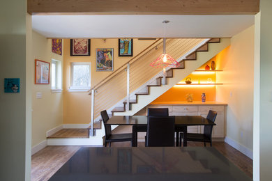 Example of a mid-sized light wood floor and brown floor kitchen/dining room combo design in Seattle with orange walls