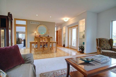Mid-sized elegant light wood floor great room photo in Milwaukee with white walls and no fireplace