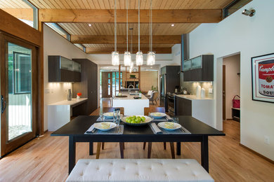 Photo of a retro kitchen/dining room in Denver with white walls and light hardwood flooring.