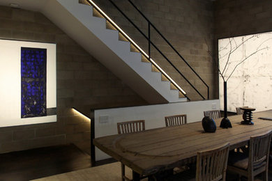 Imagen de comedor minimalista grande sin chimenea con paredes multicolor y suelo de madera oscura