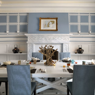 Cette image montre une salle à manger traditionnelle fermée et de taille moyenne avec un mur bleu, un sol en marbre, une cheminée standard et un manteau de cheminée en pierre.