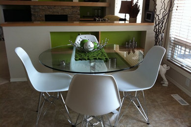 Diseño de comedor de cocina moderno con paredes verdes, suelo vinílico y marco de chimenea de piedra
