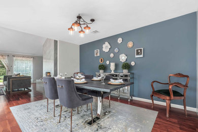 Imagen de comedor de cocina actual con paredes azules, suelo de madera en tonos medios, todas las chimeneas, marco de chimenea de piedra y suelo marrón