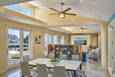 Inspiration pour une salle à manger ouverte sur le salon marine avec un sol gris et un mur beige.