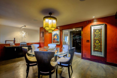 Immagine di una grande sala da pranzo boho chic chiusa con pareti rosse e pavimento in legno massello medio