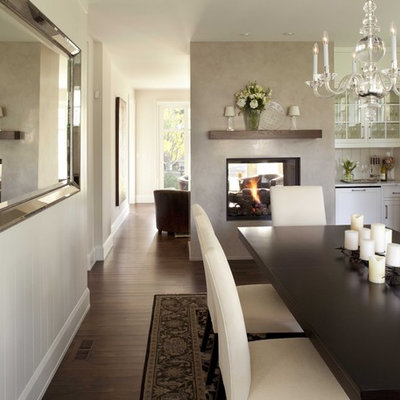 Elegant dark wood floor and brown floor enclosed dining room photo in Minneapolis with white walls, a two-sided fireplace and a plaster fireplace