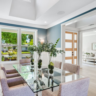 Foto di una grande sala da pranzo country chiusa con pareti blu, parquet chiaro, nessun camino, pavimento grigio, soffitto a volta e pannellatura