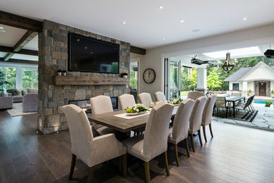 Mid-sized transitional dark wood floor and brown floor kitchen/dining room combo photo with a stone fireplace, gray walls and a two-sided fireplace