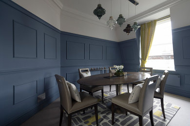 This is an example of a classic dining room in London with blue walls, carpet and no fireplace.