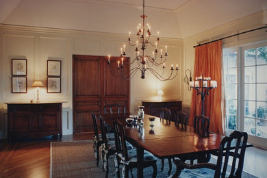 Idée de décoration pour une grande salle à manger tradition fermée avec un mur blanc et un sol en bois brun.