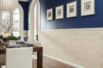 Cette image montre une grande salle à manger ouverte sur la cuisine marine avec un mur bleu et un sol marron.