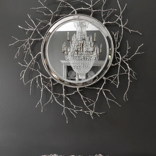 Cette image montre une grand salle à manger traditionnelle fermée avec un mur gris, un sol en bois foncé, une cheminée standard et un manteau de cheminée en pierre.