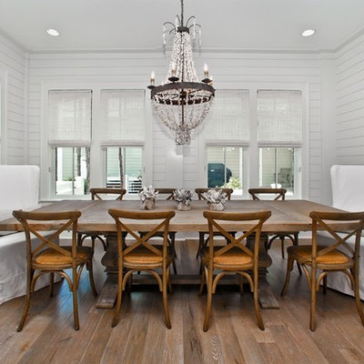 Example of a beach style medium tone wood floor dining room design in Miami with white walls