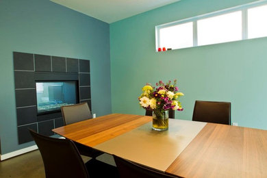Ejemplo de comedor de cocina contemporáneo grande con paredes azules, suelo de madera oscura, chimenea de doble cara y marco de chimenea de baldosas y/o azulejos
