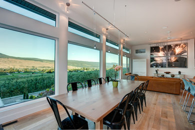 Idee per una sala da pranzo aperta verso il soggiorno minimalista di medie dimensioni con pareti bianche e parquet chiaro