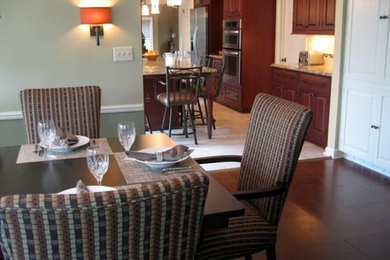 Example of a large transitional cork floor and brown floor enclosed dining room design in Milwaukee with green walls, a standard fireplace and a brick fireplace