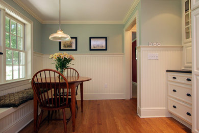 Example of a small medium tone wood floor enclosed dining room design in New York with green walls