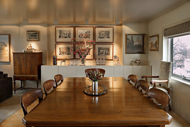 Cette image montre une grande salle à manger design avec aucune cheminée, un mur beige, un sol en bois brun et un sol marron.