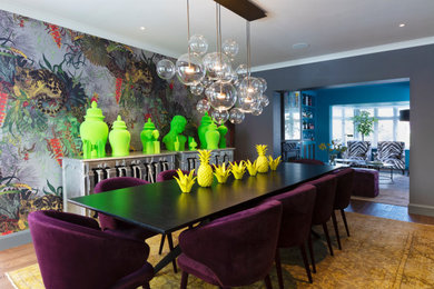 Large bohemian enclosed dining room in London with grey walls, brown floors, medium hardwood flooring, no fireplace and wallpapered walls.