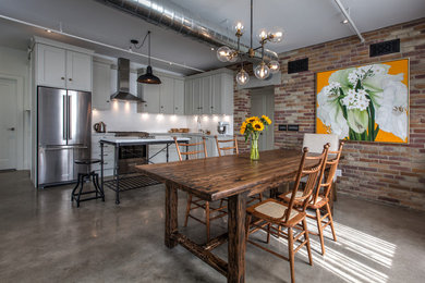 Esempio di una sala da pranzo aperta verso la cucina eclettica di medie dimensioni con pareti multicolore, pavimento in cemento, nessun camino e pavimento grigio