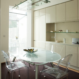 Immagine di una sala da pranzo aperta verso la cucina minimal con pareti beige, moquette e pavimento viola