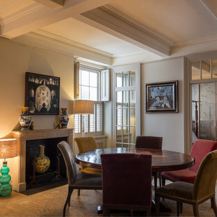 Design ideas for a traditional enclosed dining room in London with beige walls, light hardwood flooring, a standard fireplace and beige floors.