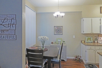 Aménagement d'une petite salle à manger ouverte sur la cuisine éclectique avec un mur jaune, un sol en bois brun et un sol marron.