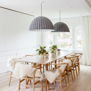 Inspiration pour une grand salle à manger nordique avec un mur blanc, un sol en bois clair, un sol beige et aucune cheminée.