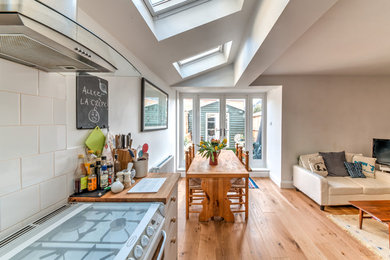 Mittelgroße Klassische Wohnküche mit weißer Wandfarbe, braunem Holzboden und braunem Boden in London