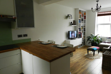 This is an example of a small contemporary kitchen/dining room in London with white walls and medium hardwood flooring.