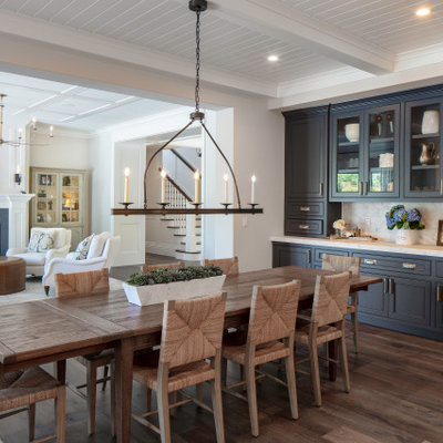 Mid-sized beach style dark wood floor, beige floor and exposed beam breakfast nook photo in San Francisco with beige walls, a standard fireplace and a stone fireplace