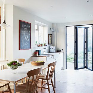 Ispirazione per una sala da pranzo aperta verso la cucina boho chic di medie dimensioni con pareti bianche