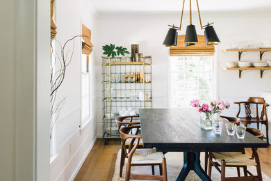 Example of a danish medium tone wood floor and brown floor enclosed dining room design in Sacramento with white walls