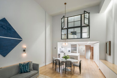 Ispirazione per una sala da pranzo aperta verso il soggiorno moderna di medie dimensioni con pareti grigie, parquet chiaro e pavimento beige