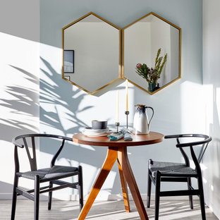 Ispirazione per una piccola sala da pranzo aperta verso la cucina minimalista con pareti blu, pavimento in vinile e pavimento grigio