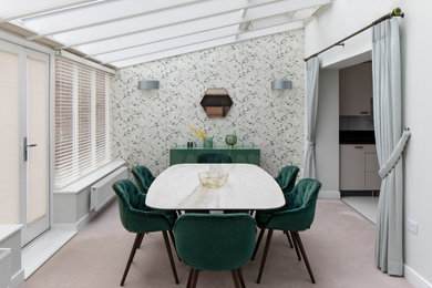 Medium sized scandi open plan dining room in Kent with green walls, carpet, no fireplace and beige floors.