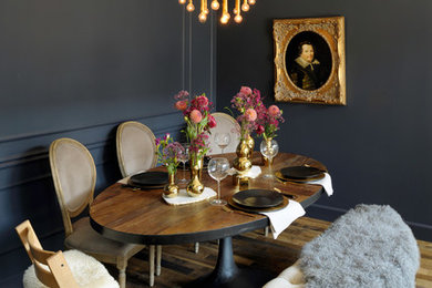 Example of an eclectic dark wood floor and brown floor dining room design in St Louis with black walls