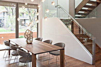 Imagen de comedor moderno de tamaño medio abierto sin chimenea con paredes blancas, suelo de madera en tonos medios y suelo beige