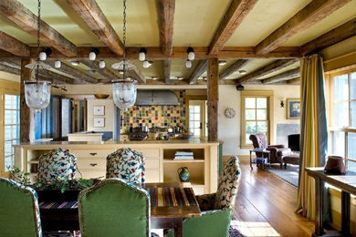 Cette photo montre une très grande salle à manger ouverte sur la cuisine montagne avec un mur jaune, un sol en bois brun, aucune cheminée et un sol marron.