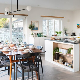 This is an example of a nautical dining room in Cornwall with white walls and beige floors.